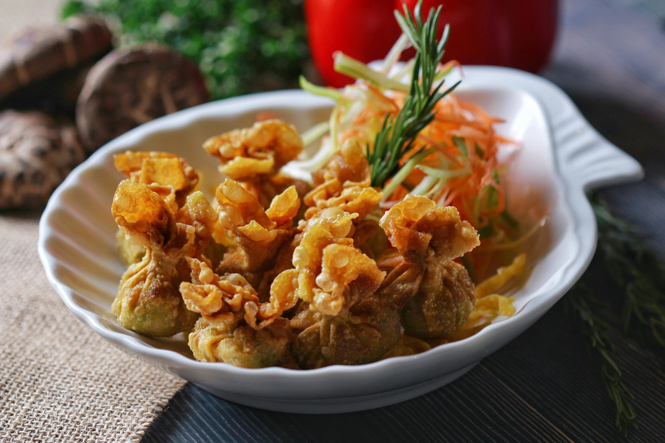 Delicious crispy fried dumplings served on a decorative plate with fresh vegetable garnish.